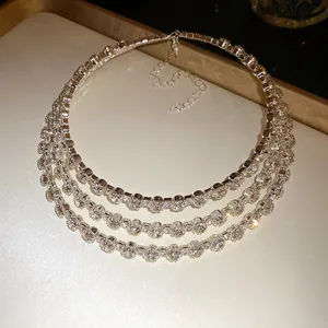 Detailed macro shot of a sparkling silver-tone three-layer rhinestone choker necklace accessory.