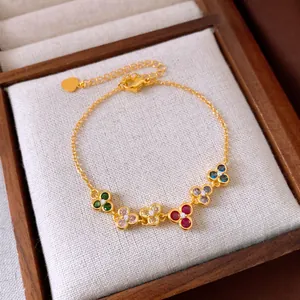 Bracelet doré élégant orné de grappes de fleurs colorées et de zircons scintillants