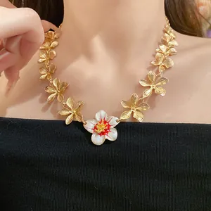 Collana floreale dorata vintage con dettaglio in smalto bianco su modella asiatica