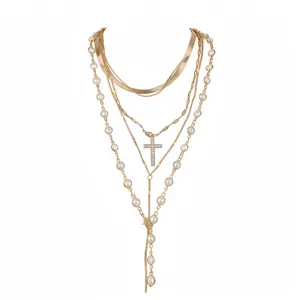 Elegant multi-layered gold necklace with pearls and sparkling crystal cross pendant.