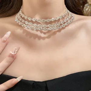 Close-up view of an elegant three-layer rhinestone choker necklace on a model's neck