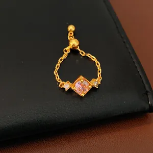 Gros plan de la bague ajustable dorée avec zircon rose losange