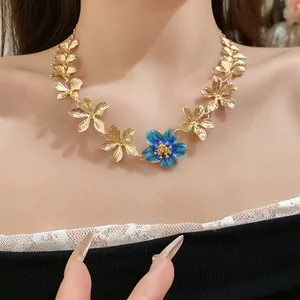 Primo piano dettagliato di una collana di fiori d'oro in stile palazzo e smalto blu.