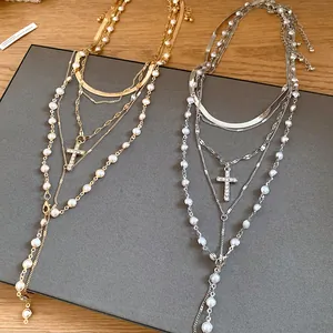 Detail view of multi-layered pearl necklaces with sparkling rhinestone cross pendants