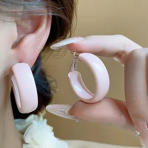 Detail view of pink lacquer hoop earrings with silver needles featuring a sweet style