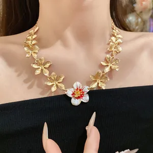 Dettaglio di una collana vintage di fiori d'oro con ciondolo floreale in smalto