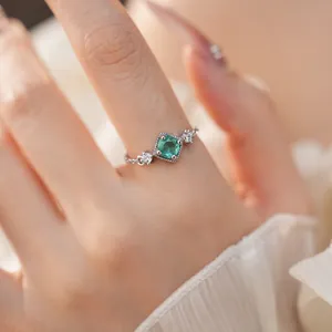 Gros plan détaillé d'une bague délicate en argent avec un zircon vert carré