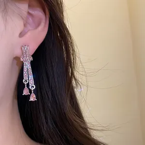 Vintage silver earrings with elegant pink rhinestone waterdrop pendants worn on ear.