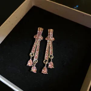 Detail view of elegant vintage pink rhinestone drop earrings in a black jewelry box