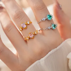 Gros plan sur d'élégantes bagues chaîne ajustables en zircon avec pierres colorées