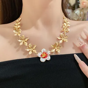 Dettaglio della collana vintage con fiori in smalto con petali dorati e bocciolo bianco-rosso