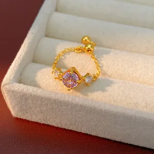Vue détaillée d'une bague dorée réglable ornée d'un zircon violet carré.