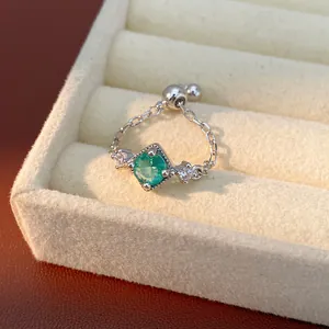 Gros plan d'une bague ajustable avec un zircon vert de forme carrée élégante