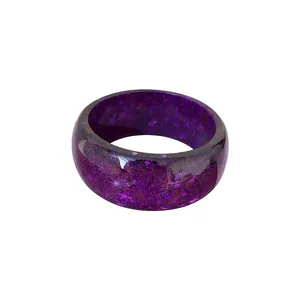 Sparkling purple resin bangle bracelet with star-shaped sequins and glitter, fashion accessory.