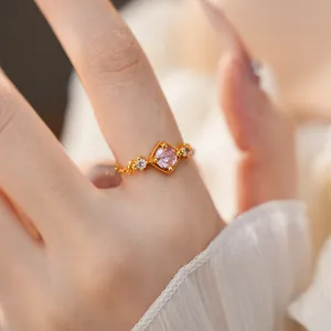 Détail d'une bague dorée ajustable ornée d'une pierre de zircon rose carrée élégante