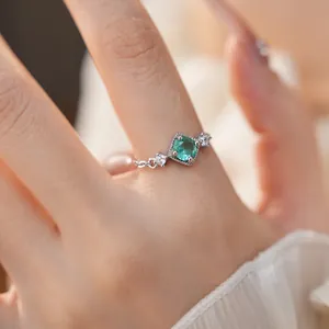 Vue macro d'une bague en argent ajustable avec zircon vert et détails de chaîne