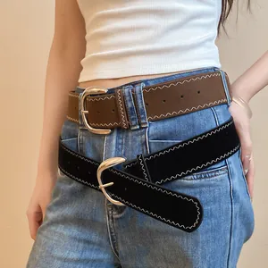 Detailed shot of two wide belts with white zigzag stitching and silver oval buckles