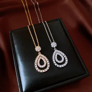 Detailed macro view of two vintage teardrop necklaces with shimmering white zircons.