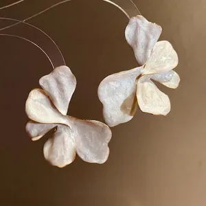 Elegant white enamel flower stud earrings with French vintage gold trim design.