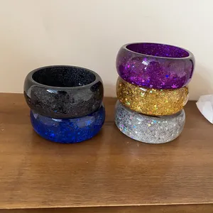 Detailed macro view of colorful chunky resin bangles with embedded glitter and star sequins