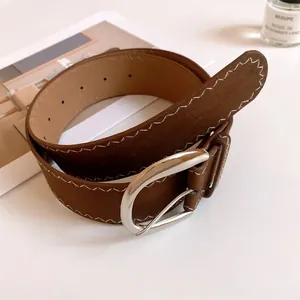 Detailed view of a brown leather belt featuring white zigzag stitching and silver buckle