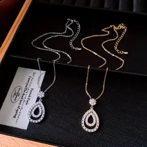 Close-up of elegant gold and silver zircon teardrop pendants in a display case