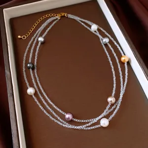 Close-up of elegant three-layer necklace with faceted crystal beads and multi-colored pearls