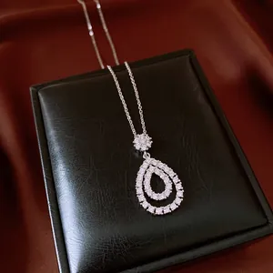 Macro detail of a vintage pear-shaped zircon pendant necklace on a black leather box