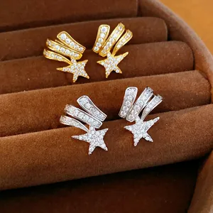 Detail of zircon-encrusted shooting star ear clips in gold and silver finishes.