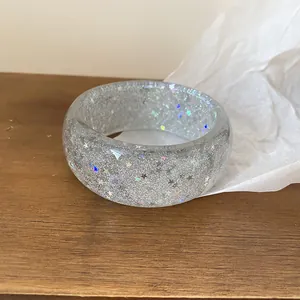 Close-up of clear resin bangle with silver glitter and holographic stars
