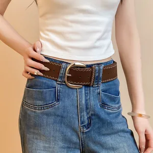 Close-up of brown leather belt with white zigzag stitching and silver buckle