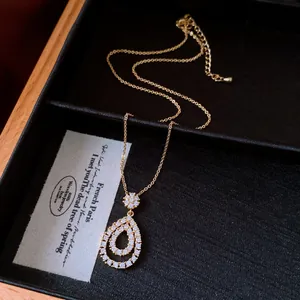 Detailed view of retro gold-toned necklace with zircon-encrusted teardrop pendant