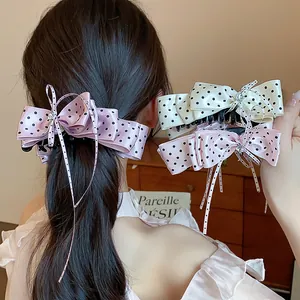 Gros plan de pinces à cheveux à nœud à pois élégantes avec détails en cristal rose