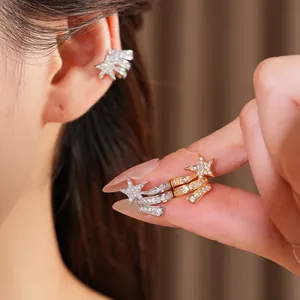 Close-up detail of zircon-encrusted star triple-layer ear cuffs in silver and gold