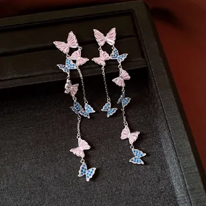 Detailed view of elegant silver needle butterfly tassel earrings with pink and blue zircons