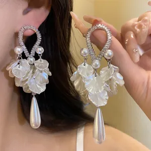 Close-up of elegant water drop earrings with pearls and zircon details