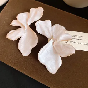 Exquisite detail view of pearlescent French vintage flower stud earrings with elegant gold edges