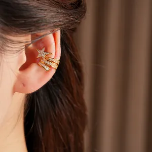 Detail view of an elegant gold-toned star ear cuff with sparkling zircon inlay on ear