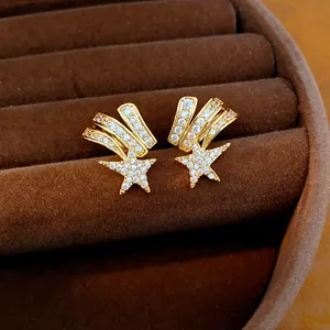 Detail of elegant shooting star ear clips with sparkling cubic zirconia on brown velvet