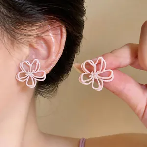 Vista dettagliata di orecchini a fiore rosa traforati con finitura smaltata elegante.