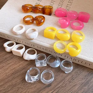 Detailed macro view of vintage resin rings in various colors displayed on a cream book