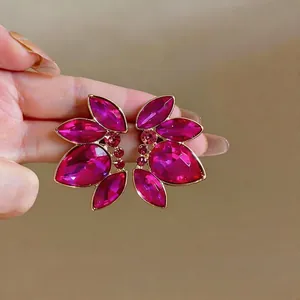 Eleganti orecchini a lobo in cristallo fucsia con raffinato design a petali dorati