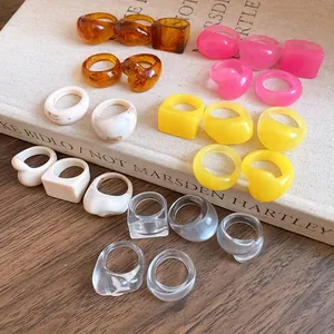 Detail shot of colorful resin rings in square and wavy designs on a vintage book.