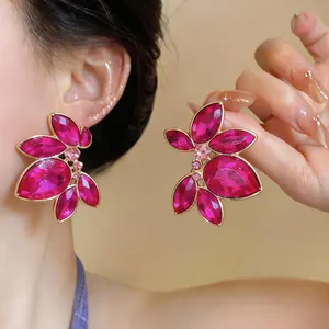 Primo piano di orecchini a fiore in cristallo fucsia con petali a forma di goccia vivaci