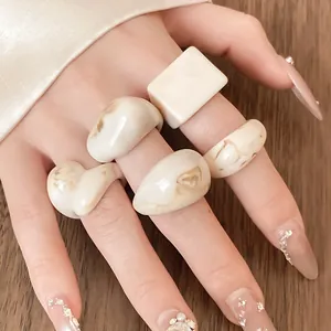 Set of cream resin rings with marbled texture shown on hand