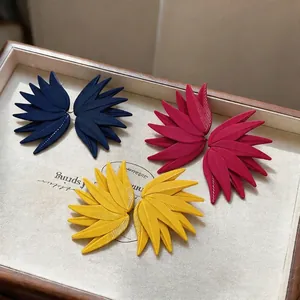 Set of three colorful leaf-patterned matte earrings in navy, magenta, and yellow colors.