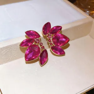 Primo piano dettagliato di eleganti orecchini in cristallo rosa a forma di foglia dorata