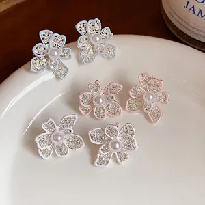 Eleganti orecchini a lobo a fiore traforato con perla centrale e finitura smaltata.
