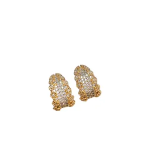 Eleganti orecchini a forma di C in oro con brillanti zirconi cubici su sfondo bianco