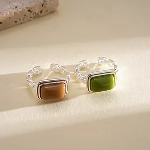 Detailed close-up of green and brown resin square rings featuring silver chain bands